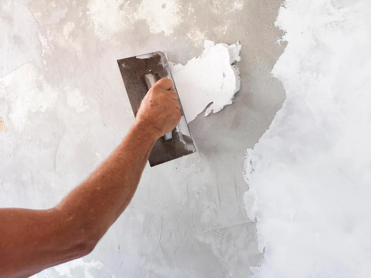 Verputzer glättet eine Innenwand mit der Glättkelle